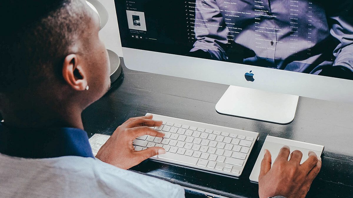 Elegencki mężczyzna przegląda spotify na iMac